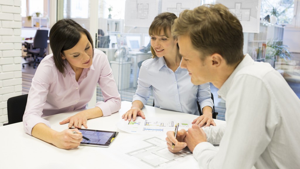 Group of architects working in an office using a tablet