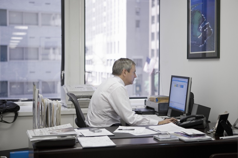 man in office using computer